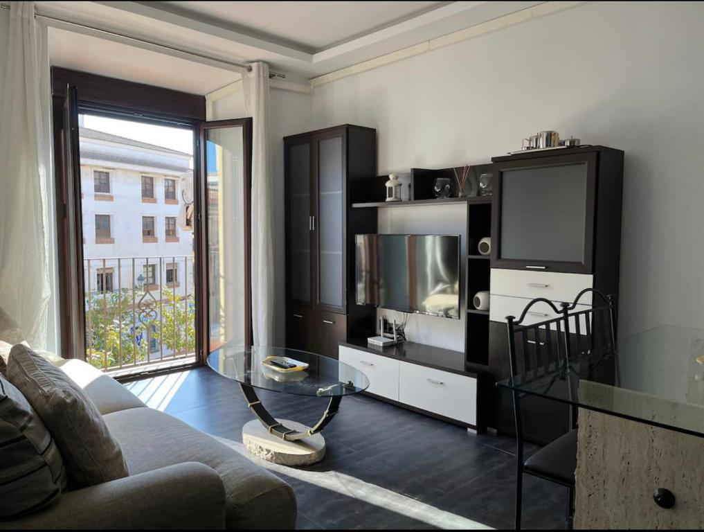 a living room with a couch and a tv at Rondabella 3 Parking Gratis Centro in Ronda