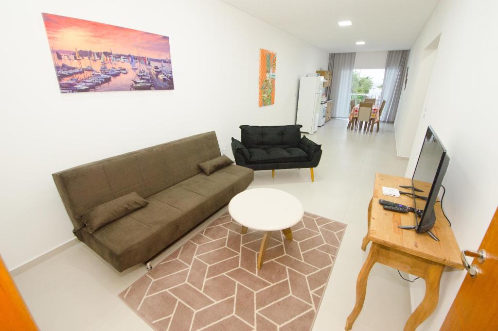 uma sala de estar com um sofá e uma mesa em Apartamentos Sinhá em Penha