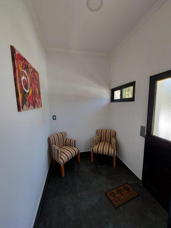 twee stoelen in een kamer met witte muren en een raam bij Dto Urquiza in Concordia