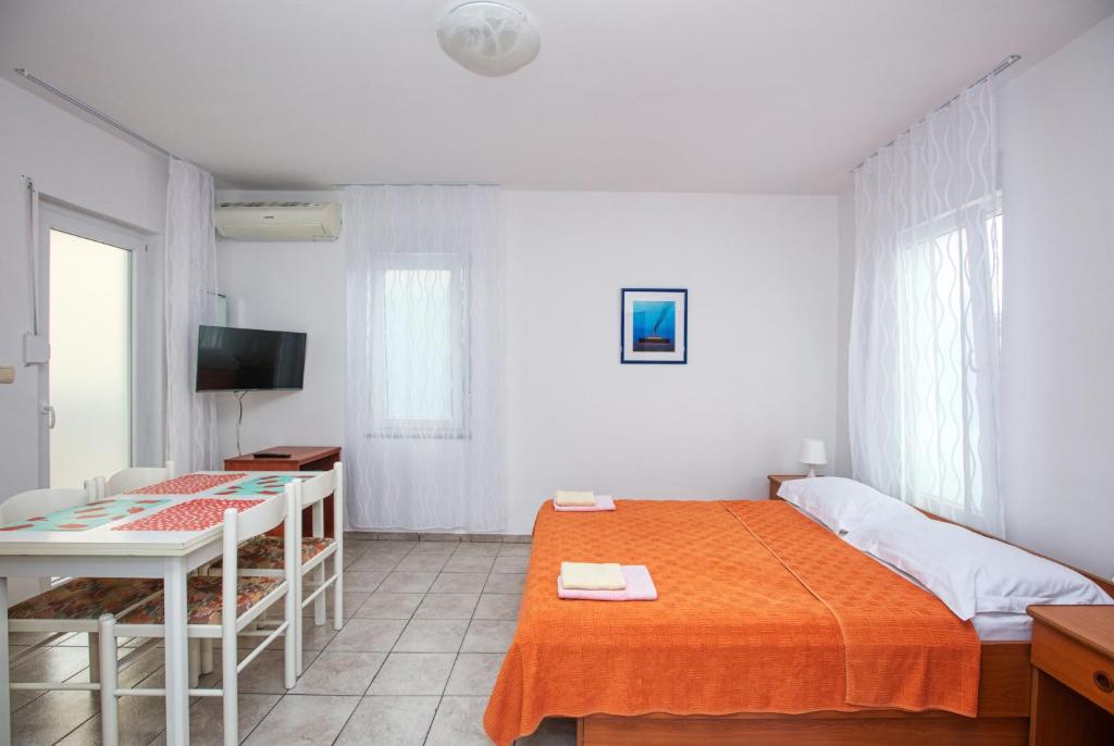 Apartments with parking space Pirovac, Sibenik - 15320 في بيروفاتش: غرفة نوم بها سرير ومكتب وتلفزيون