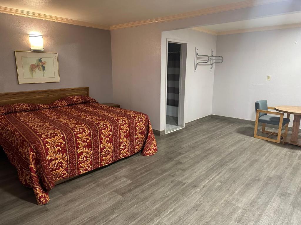 um quarto de hotel com uma cama e uma mesa em Plaza Inn Motel - Los Angeles area em Rosemead