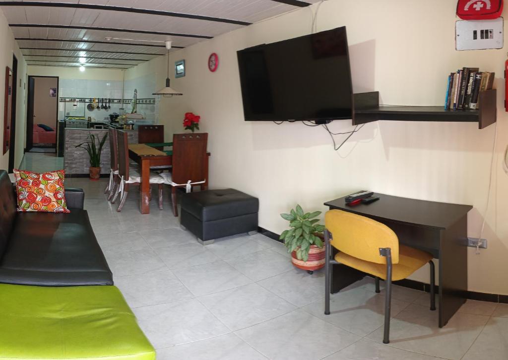 a living room with a desk and a tv on the wall at Acogedor Apartamento en Centro de Popayán in Popayan