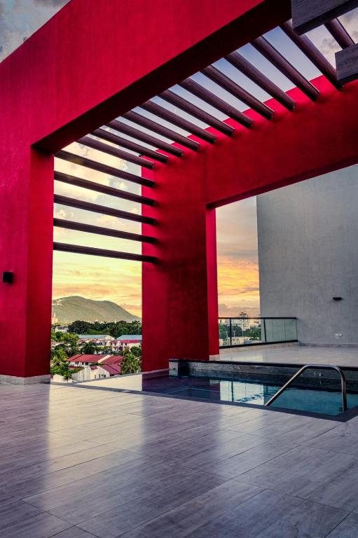 a room with a red wall and a swimming pool at Parkhurst Lux Condo Near Devon House in Kingston