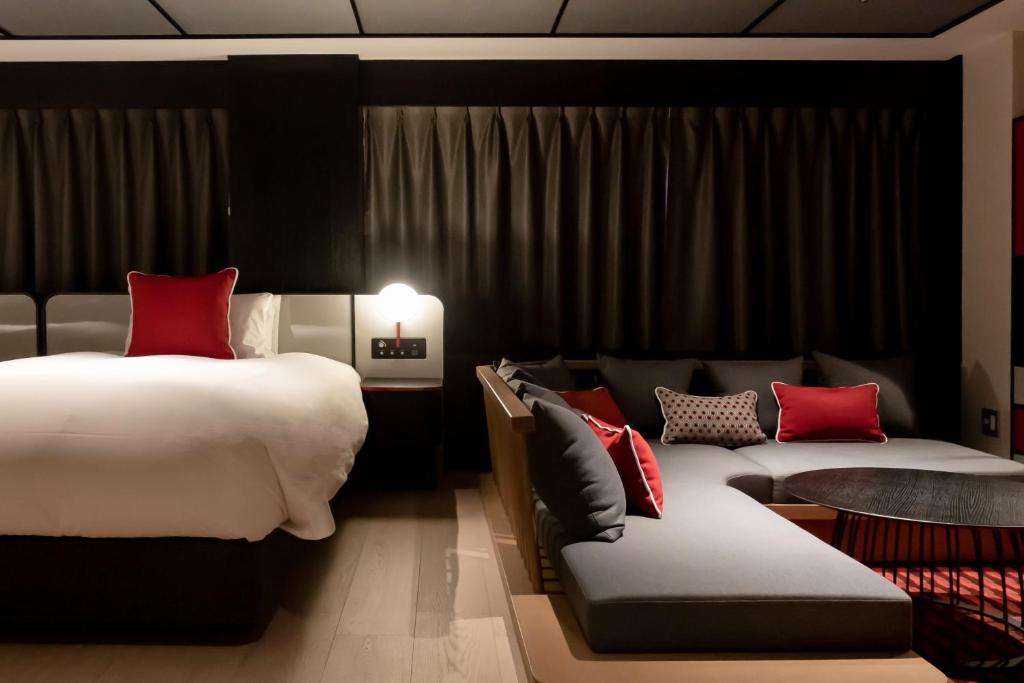 a hotel room with a bed and a couch at Cross Hotel Osaka in Osaka