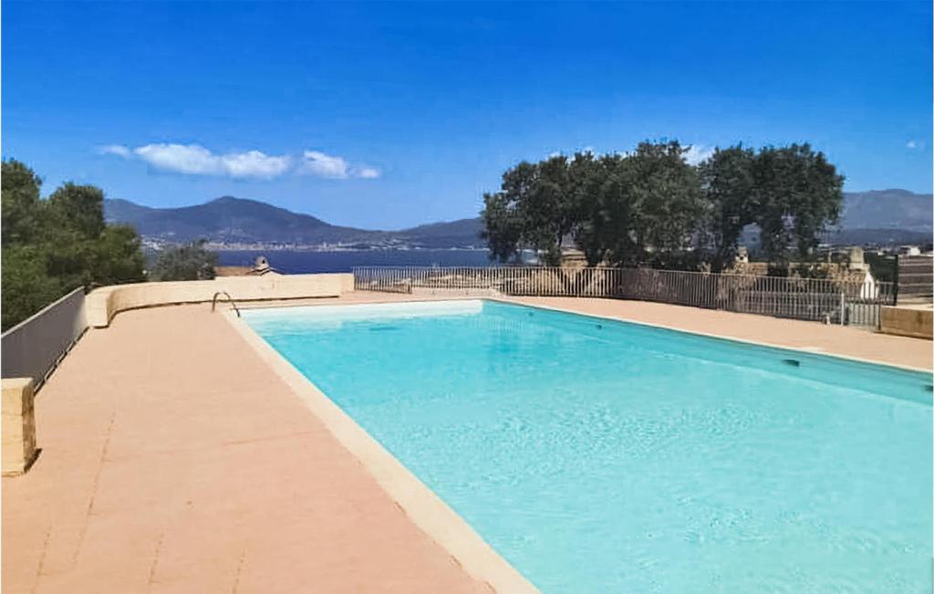 una grande piscina blu con vista sull'acqua di 2 Bedroom Nice Home In Grosseto-Pugna a Porticcio