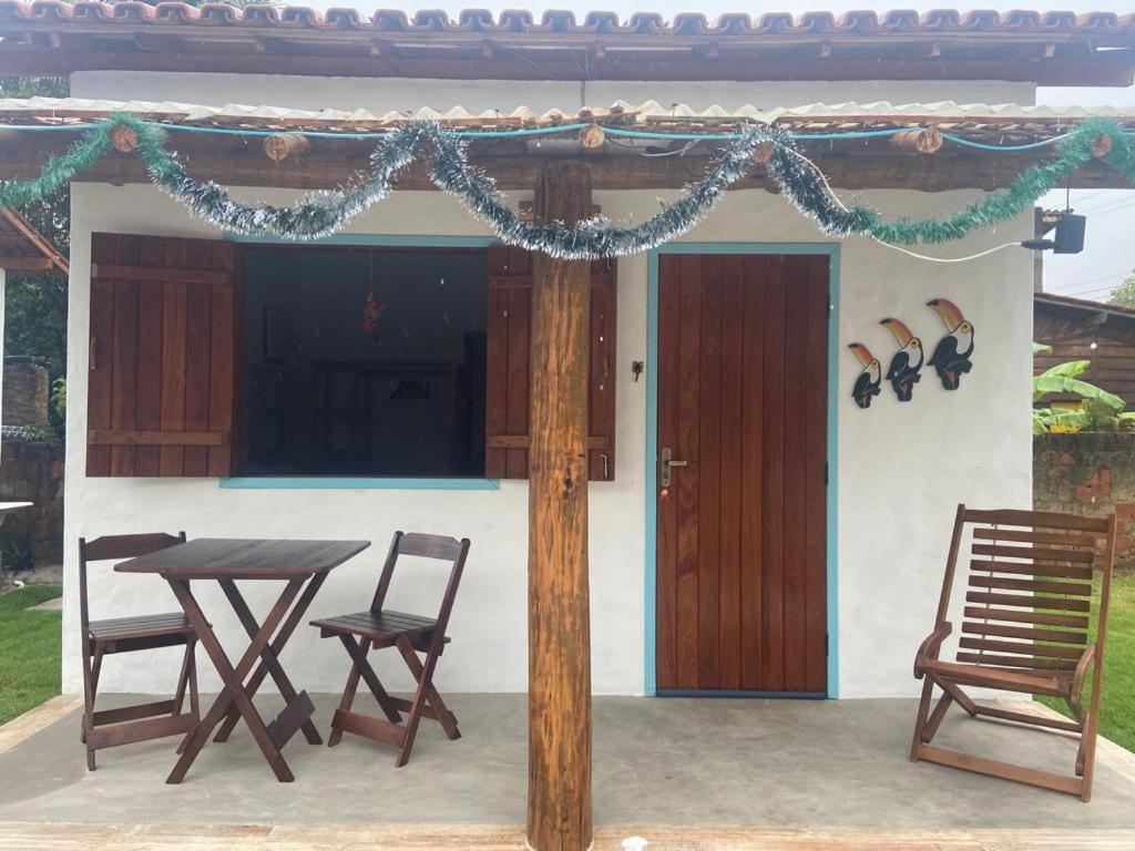 een tafel en stoelen voor een huis bij CHALÉS MELGAÇO in Cumuruxatiba