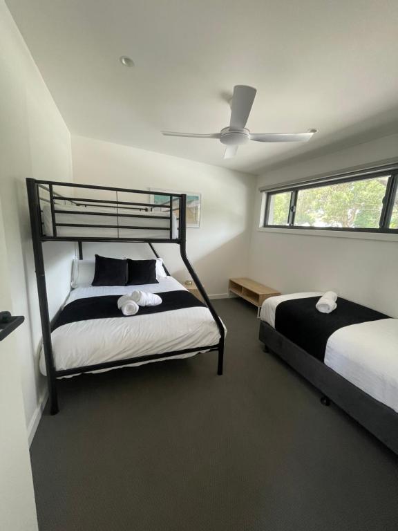 a bedroom with two beds and a ceiling fan at Inverloch Motel in Inverloch
