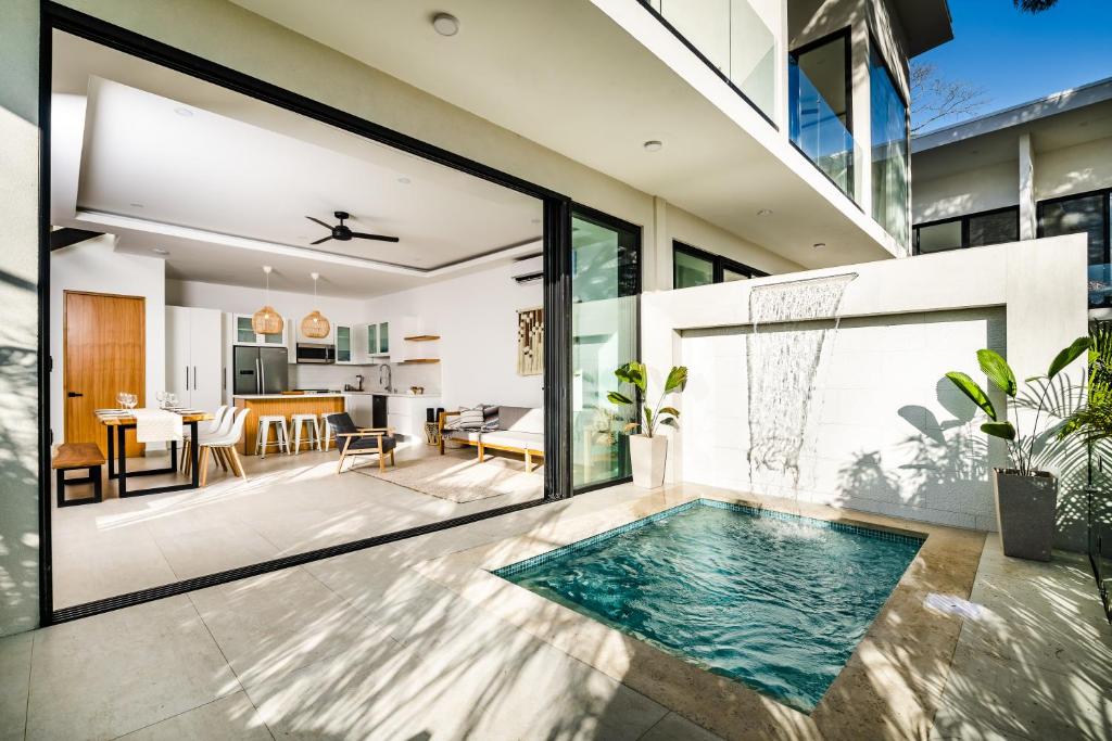 an open living room and dining room with a swimming pool in a house at The mVilla with Exclusive Beach Club Access in Tamarindo