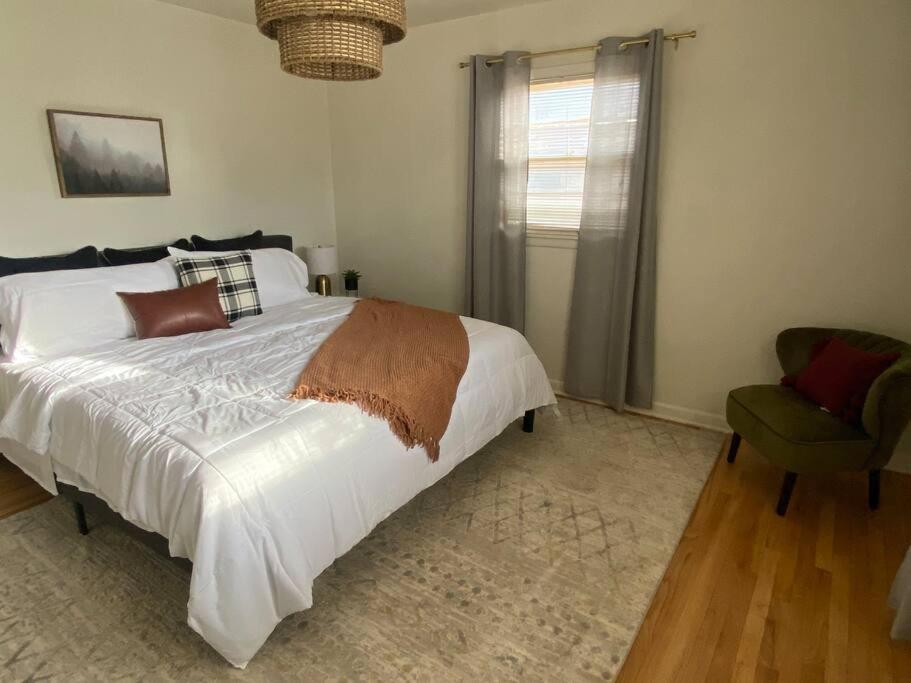 um quarto com uma cama branca e uma cadeira em 3BR 2min from I-40,near DT, 21 min Palo Duro em Amarillo