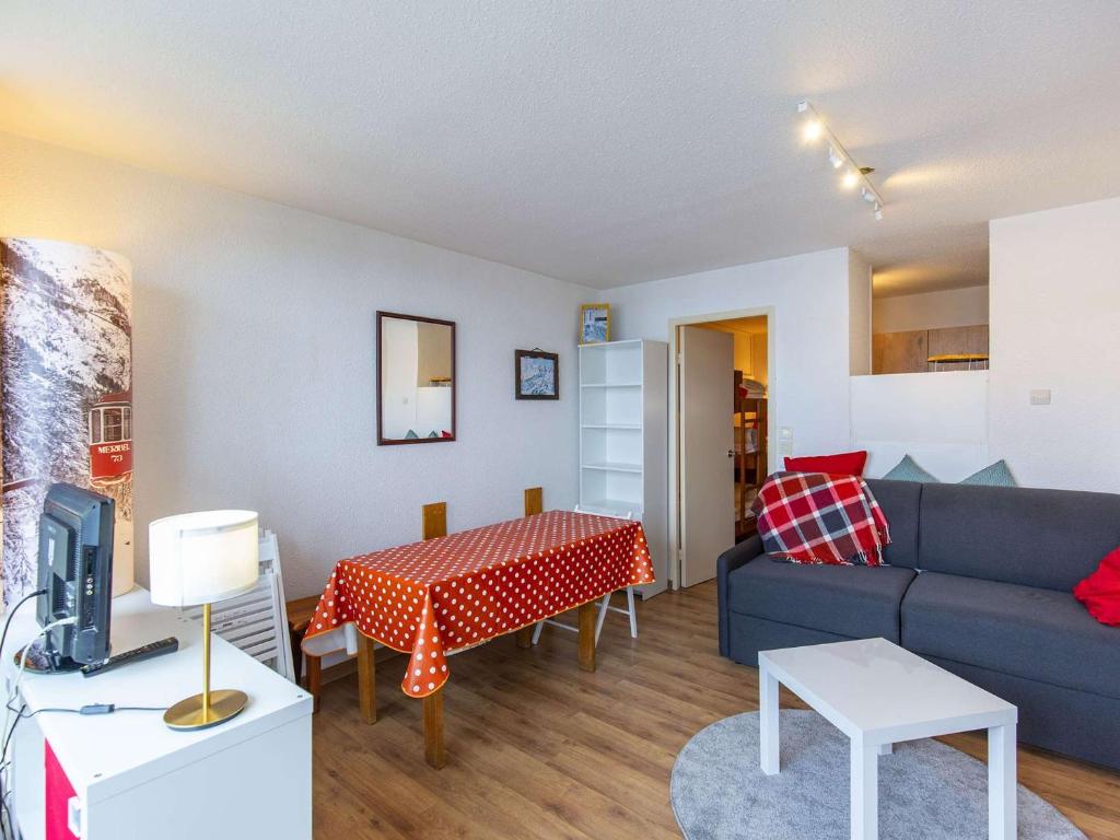een woonkamer met een bank en een tafel bij Studio La Mongie, 1 pièce, 5 personnes - FR-1-404-343 in Bagnères-de-Bigorre