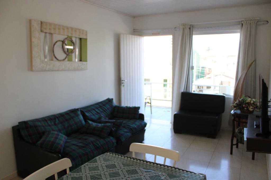een woonkamer met een bank en een stoel bij Apartamento em Torres in Torres