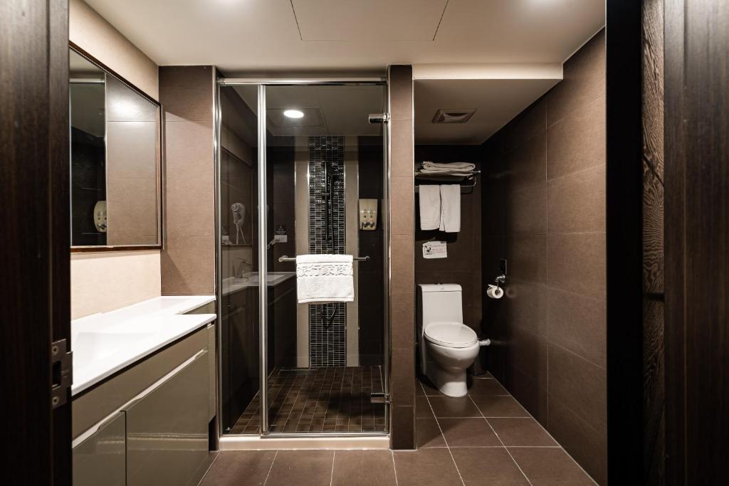 a bathroom with a glass shower and a toilet at Global Traveler Hotel in Kaohsiung