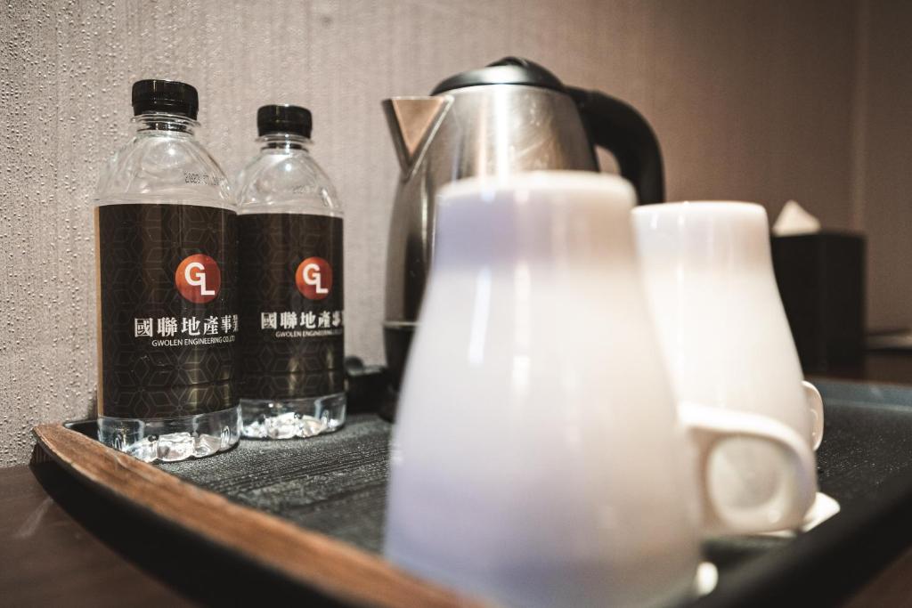 two bottles of water and a tea kettle on a table at Global Traveler Hotel in Kaohsiung