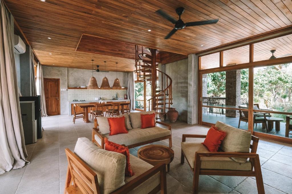 a living room with wooden ceilings and a dining room at Diamond Beach Villas in Nusa Penida