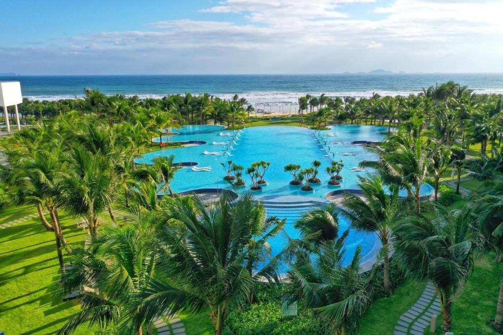 an aerial view of a resort pool with palm trees at Seaview Arena Cam Ranh Nha Trang hotel near the airport in Cam Ranh