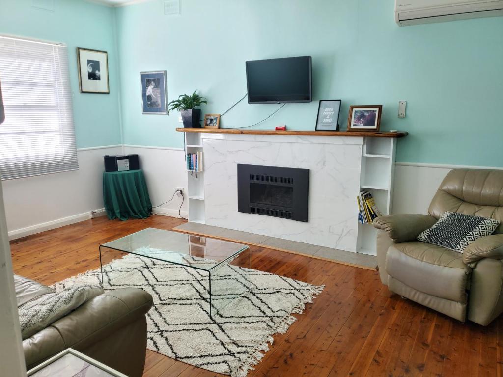 a living room with a fireplace and a tv at Coco's Cottage in Tamworth