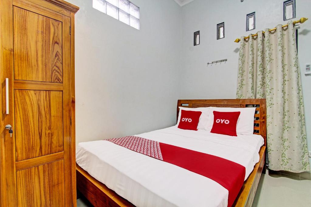 um quarto com uma cama e uma porta de madeira em OYO 92071 Yusman Homestay Syariah em Glagah