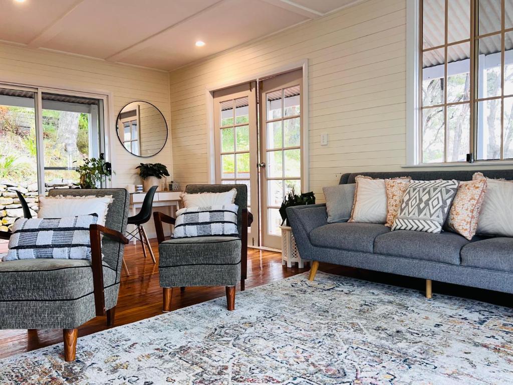 sala de estar con sofá y 2 sillas en Katoomba Hideaway - Blue Mountains Modern Getaway, en Katoomba