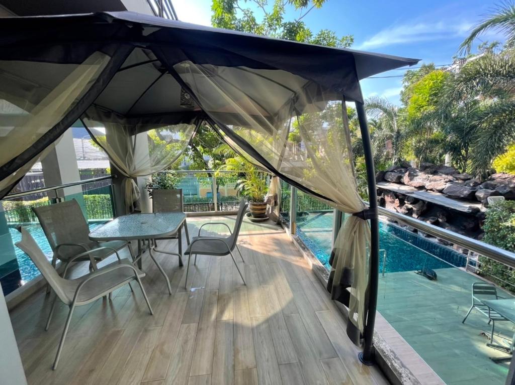 een patio met een tafel en stoelen en een parasol bij The Lux Ladprao 10 in Bangkok