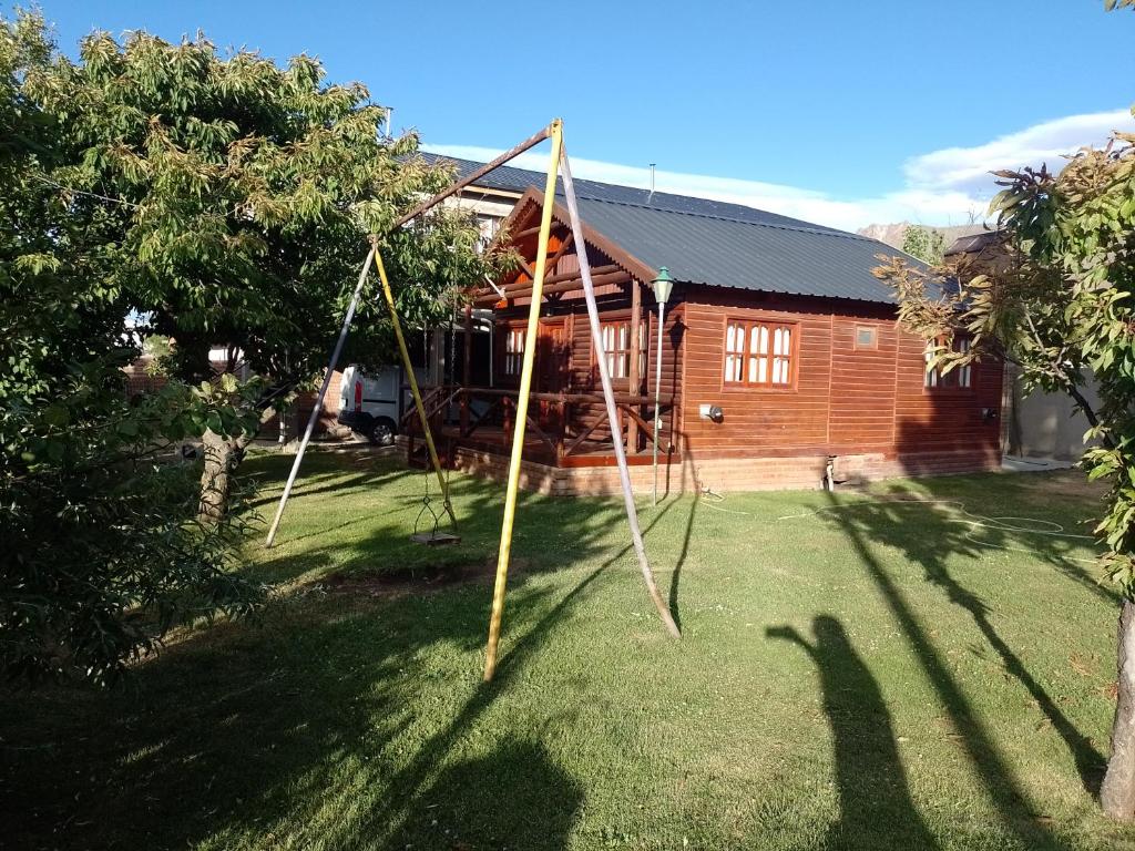 una casa con un montón de palos en el patio en Cabañas maiten, en El Maitén