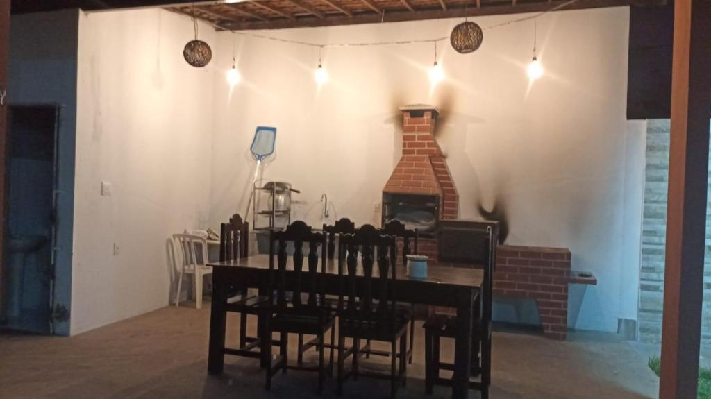 une salle à manger avec une table et une cheminée dans l'établissement Recanto ViVa - Catuama, à Goiana