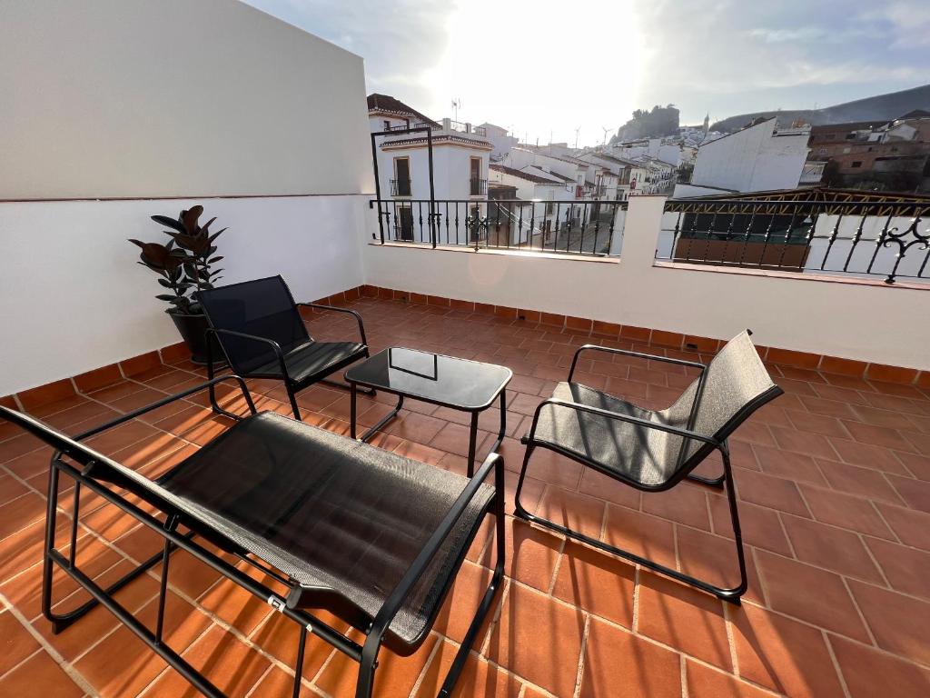 un balcón con sillas y una mesa en el techo en ATICO BUENAVISTA, en Ardales