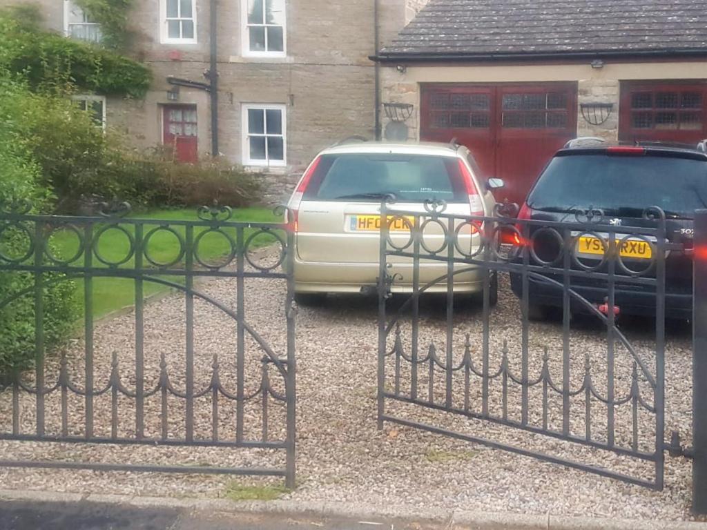 two cars parked in front of a house at Syke Cottage in Mickleton