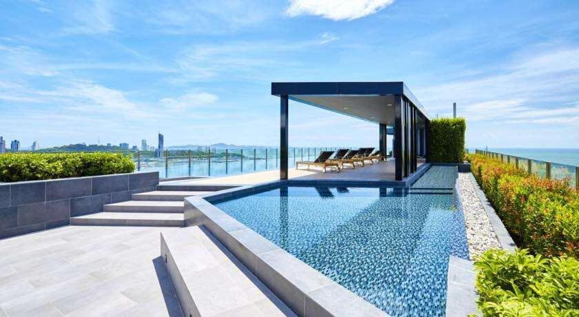a house with a swimming pool and the ocean at 泰国芭提雅无边游泳池精装修公寓临近大海两卧室 in Pattaya Central