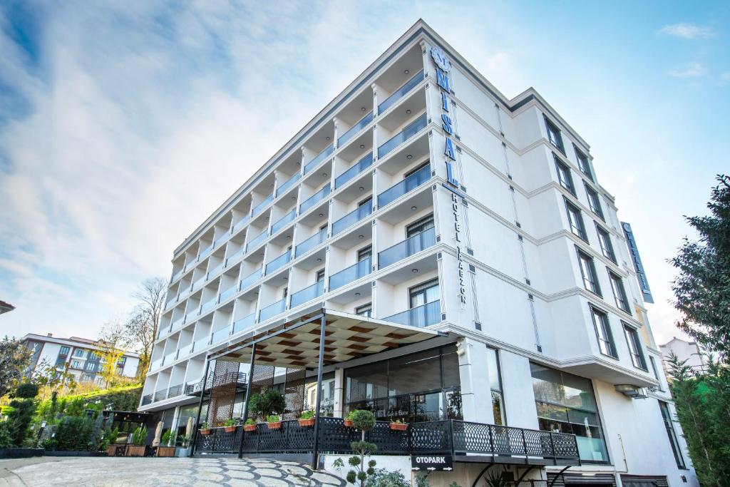 a large white building with blue windows at Misal Hotel Trabzon in Trabzon