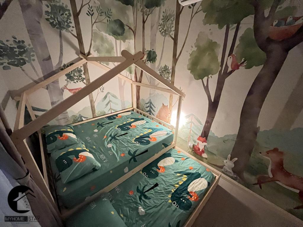 a bedroom with a bed with a forest mural on the wall at MyHomeStay@JB LEGOLAND in Nusajaya