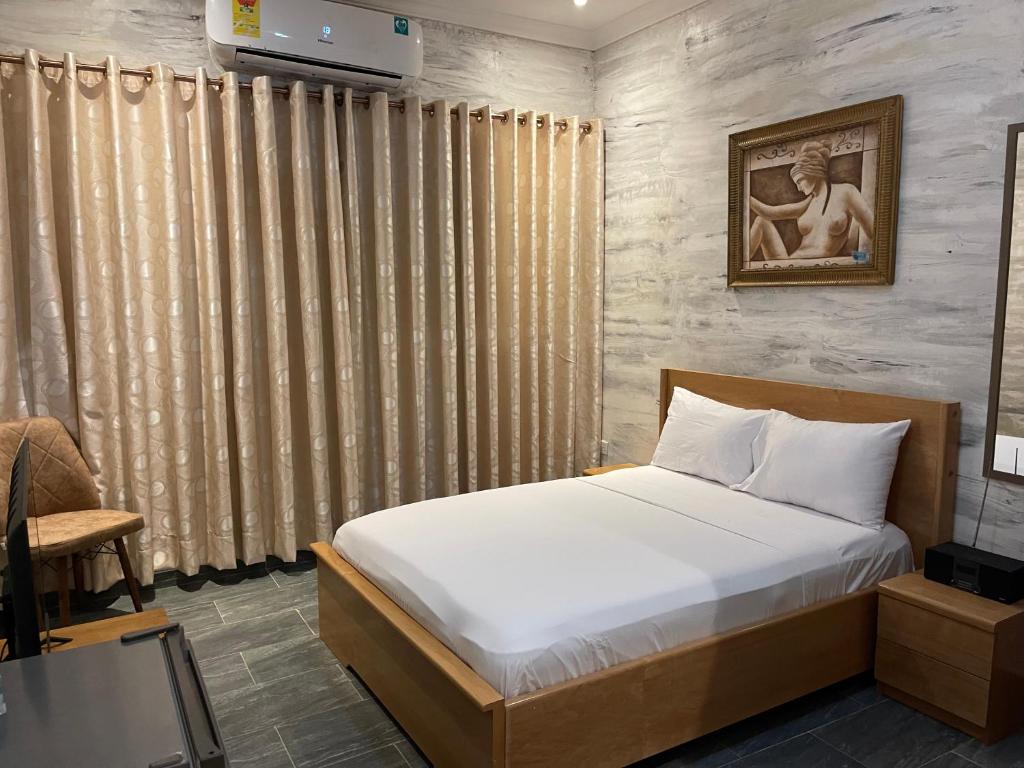 a bedroom with a bed in a room with a window at Bays Lodge - East Legon in Accra