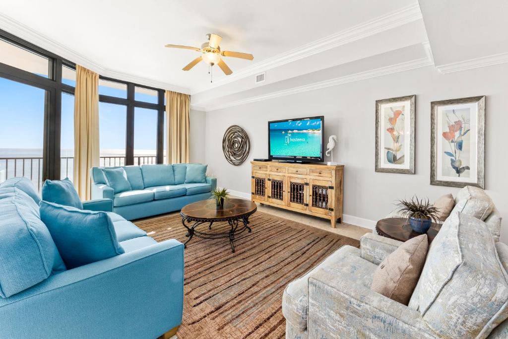 a living room with blue furniture and a flat screen tv at The Oasis at Orange Beach 2203 in Orange Beach