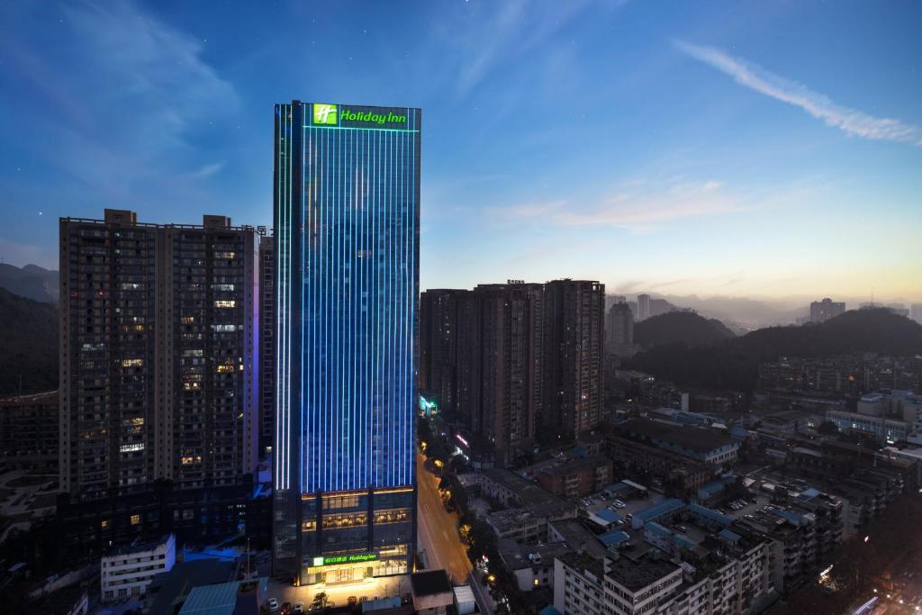 貴陽的住宿－贵阳南岳假日酒店，一座高大的建筑,上面有蓝色的灯光