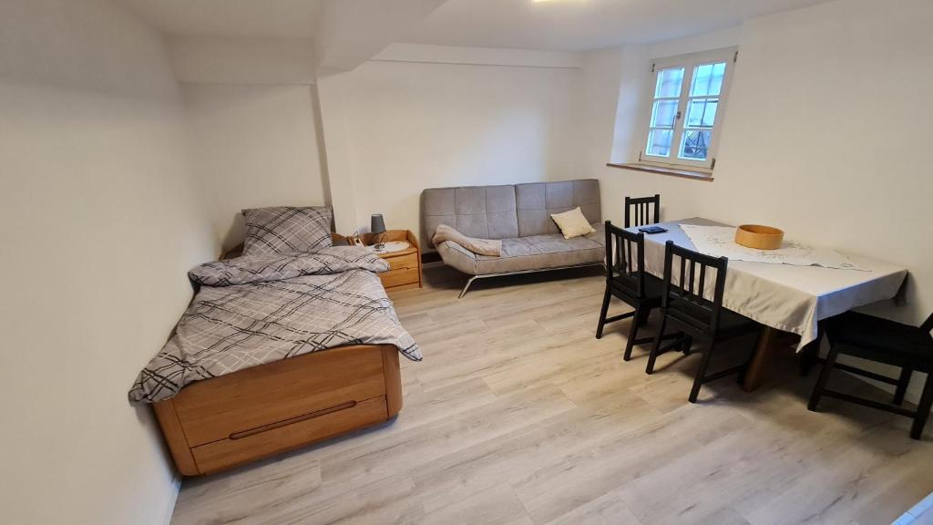 a room with a bed and a table and a couch at Ramsbacher Ferienwohnung in Schwäbisch Hall