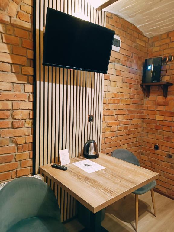 a wooden table with two chairs and a television at Pokoje Jola in Drawsko Pomorskie