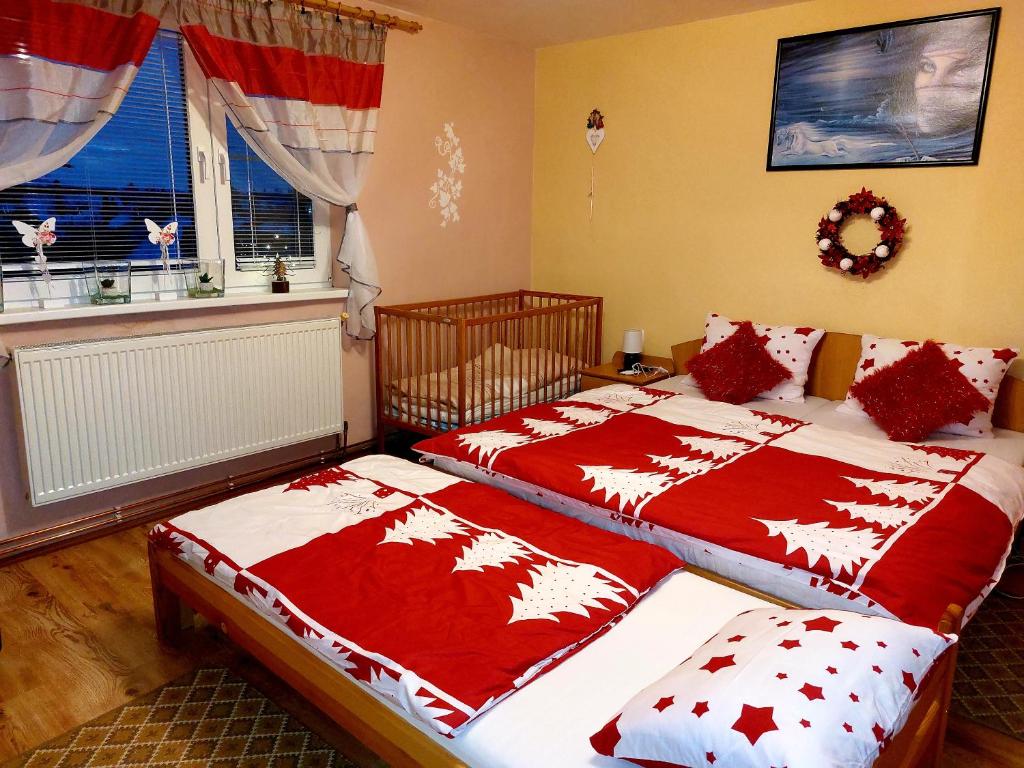 sypialnia z 2 łóżkami z czerwonymi i białymi kocami w obiekcie House Hanka, High Tatras w Starej Leśnej