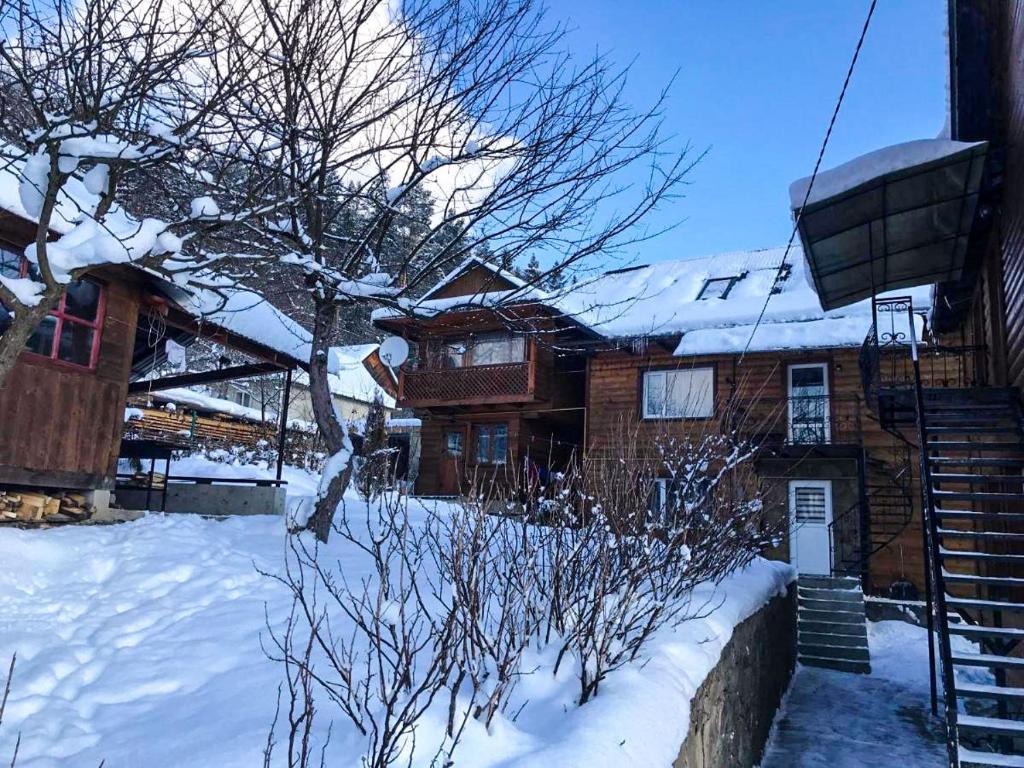 una casa con neve a terra e scale di Під лісом у гіда a Jaremče