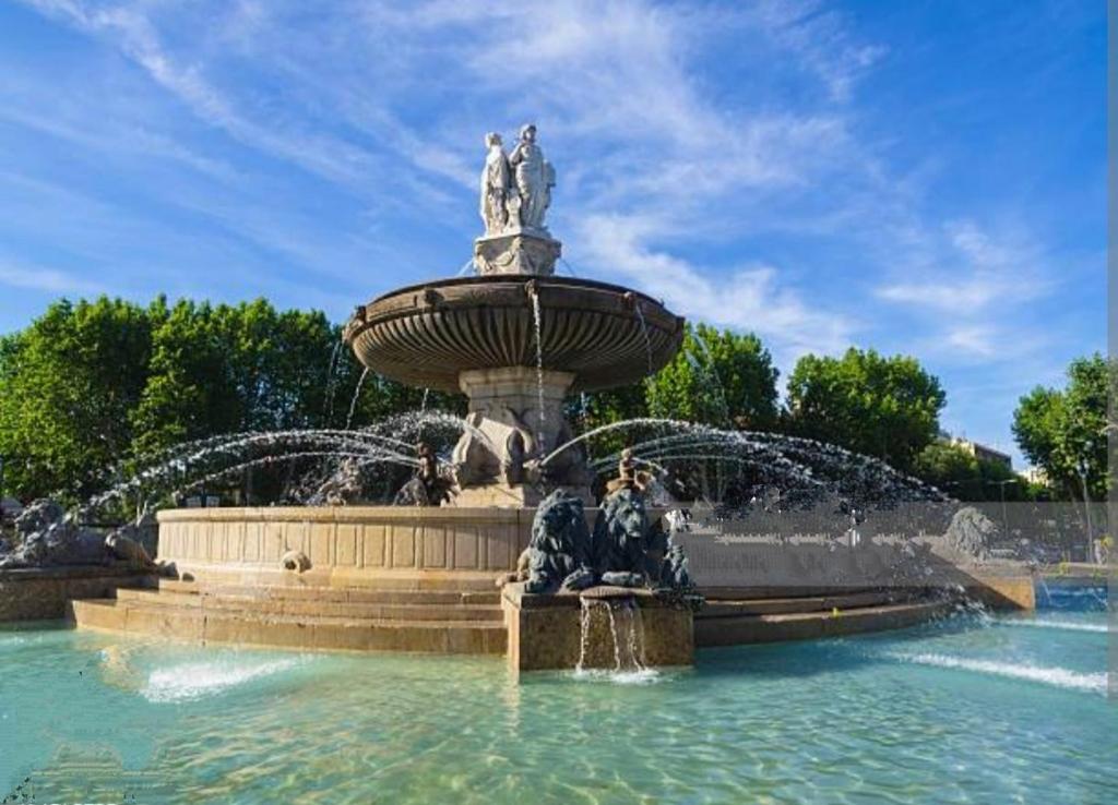 une fontaine avec deux statues en haut dans l'établissement Appart Aix sauna jacuzzi balneo spa privatifs hyper centre historique cour intérieur, à Aix-en-Provence