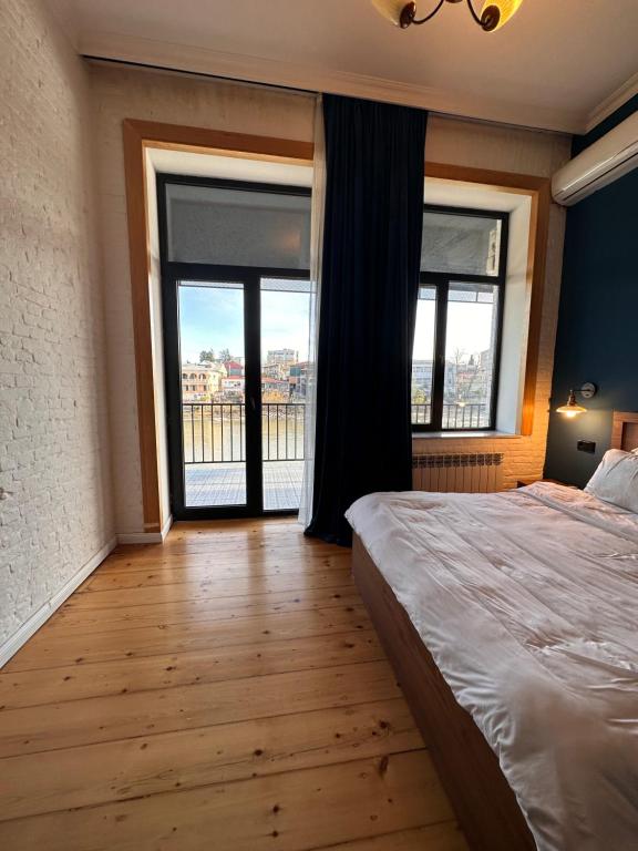 a bedroom with a large bed and a large window at Apartment Riverside in Kutaisi