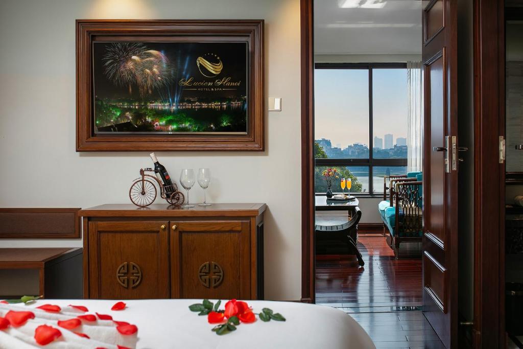 a bedroom with a bed and a table with a view at Lucien Hanoi Lakeside Hotel & Rooftop in Hanoi