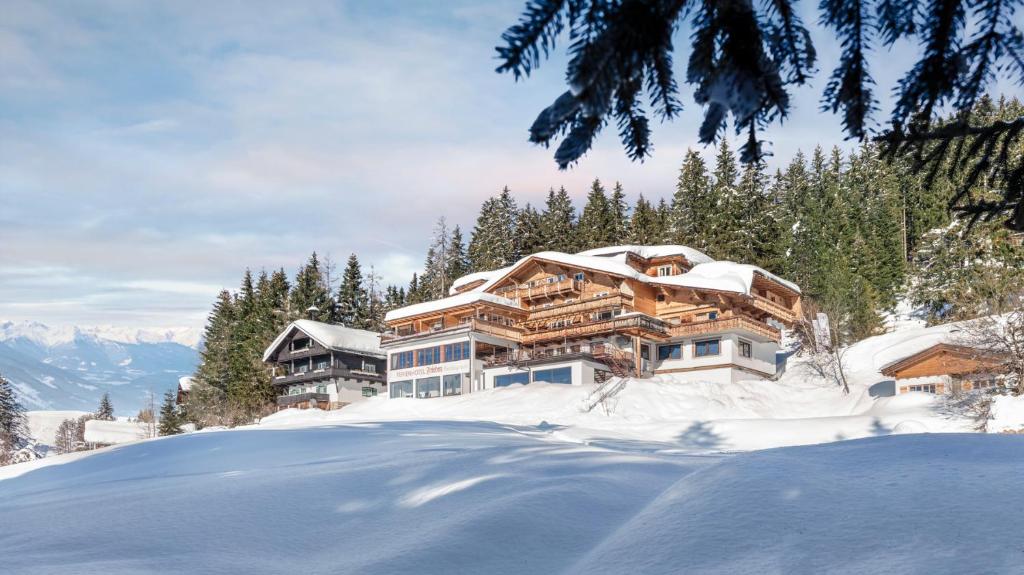 a large building covered in snow in the mountains at Frieden DAS Alpine Panorama Hotel in Pill