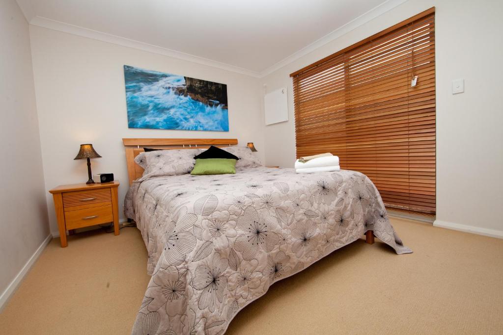 a bedroom with a bed and a large window at Ocean Mist Villa in Albany