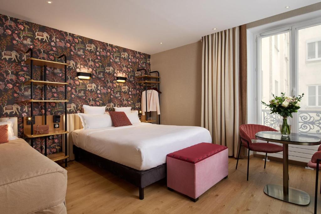 パリにあるHôtel Tourisme Avenueのベッドとテーブルが備わるホテルルームです。