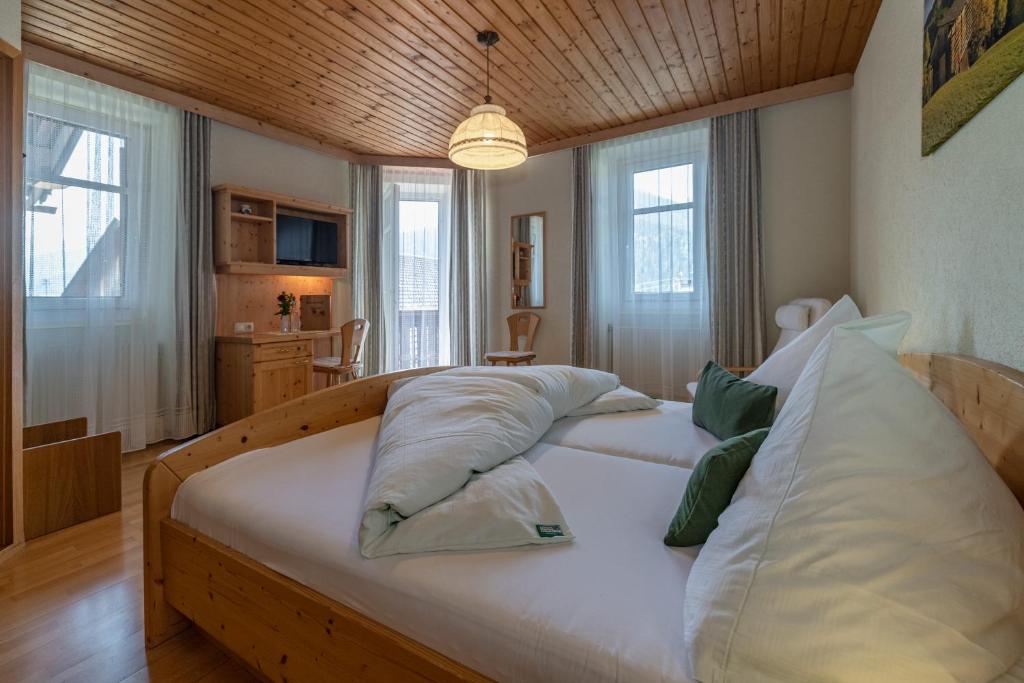 sypialnia z dużym łóżkiem z poduszkami w obiekcie Erlebenswert Bauernhof Gruber w mieście Sankt Lorenzen im Lesachtal