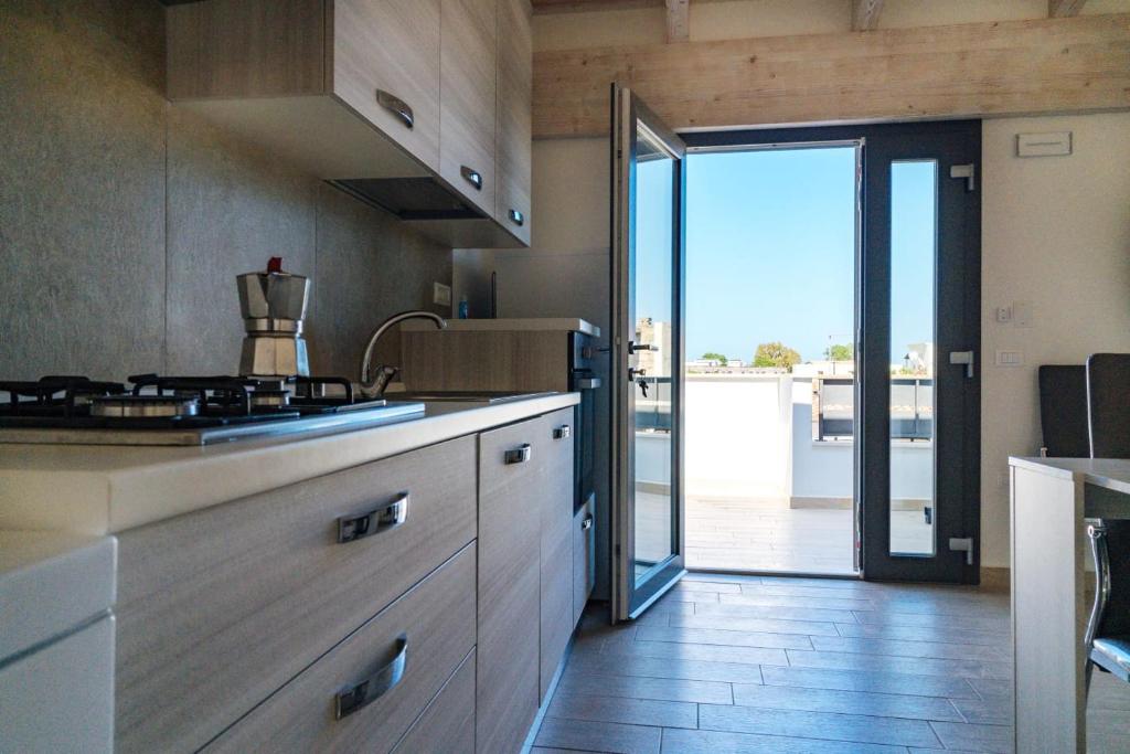 kuchnia z kuchenką i drzwi na patio w obiekcie Casa Vacanze Oltre La Caletta - 350 mt dalla spiaggia w mieście La Caletta