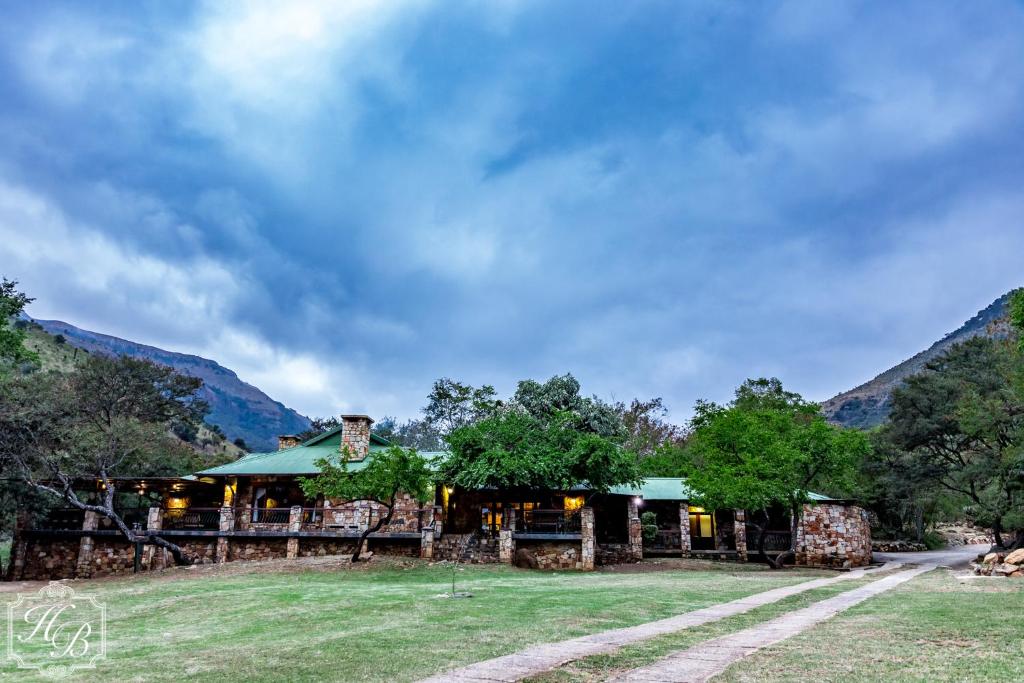 un complejo con montañas en el fondo en Heysbrook Estate - Luxurious lodges in a private valley, en Waterval-Onder