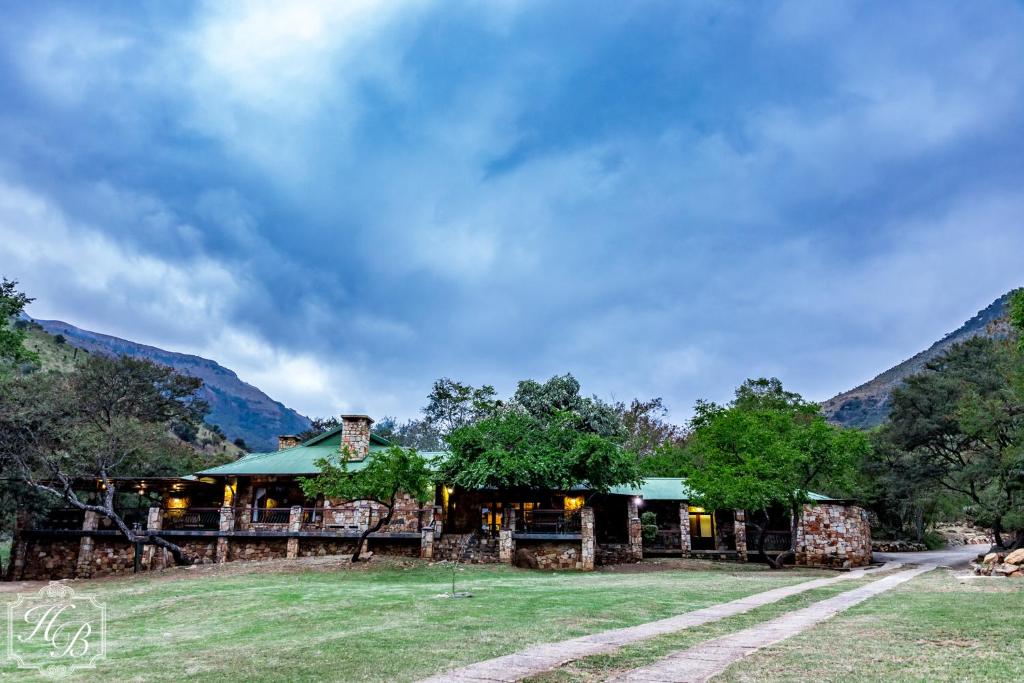 a resort with mountains in the background at Heysbrook Estate - Luxurious lodges in a private valley in Waterval-Onder
