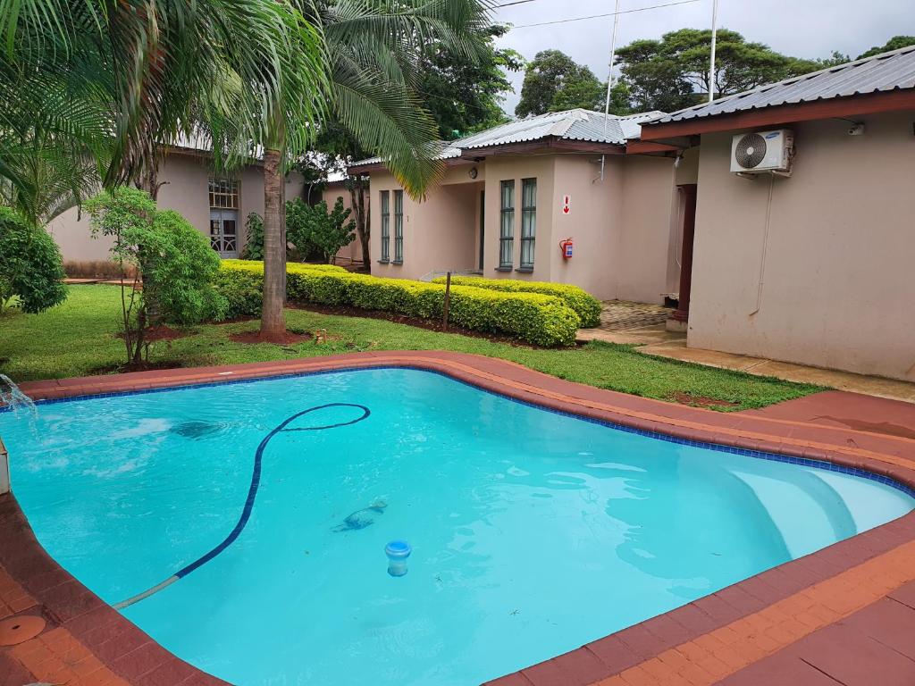 ein Pool vor einem Haus in der Unterkunft RS GARDEN GUESTHOUSE in Thohoyandou