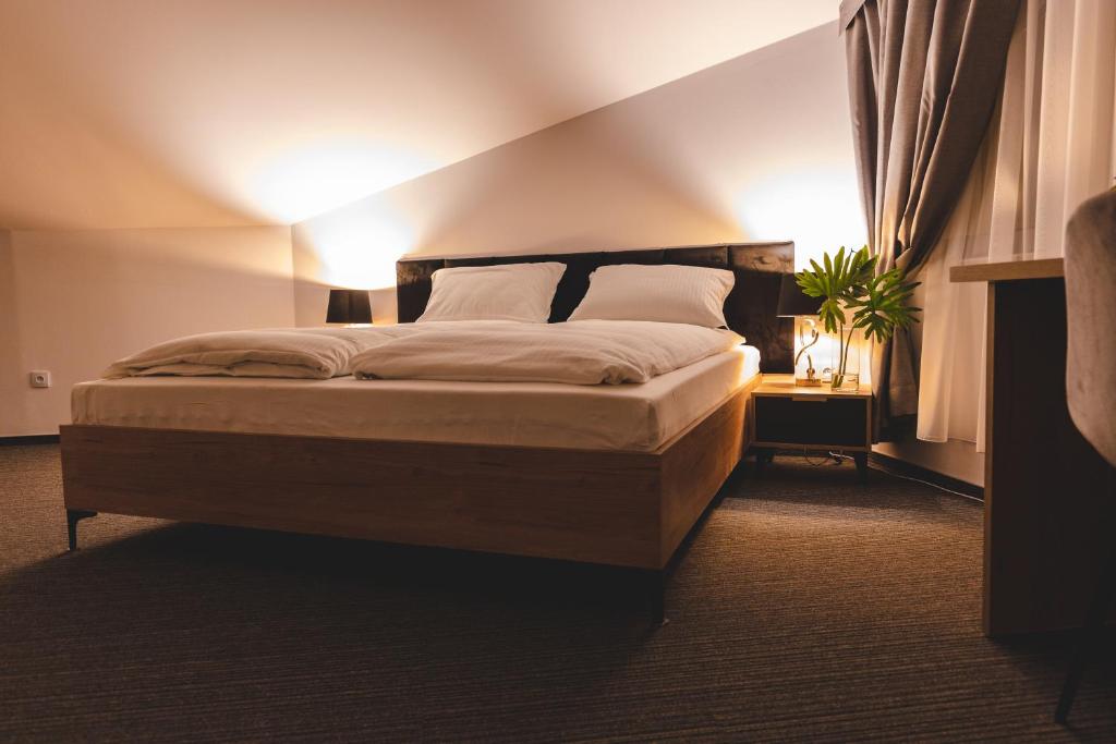 a bedroom with a large bed with two pillows at Hotel Akwawit in Leszno