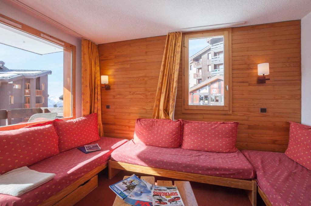 a room with two red couches and a window at Résidence Pierre &amp; Vacances Emeraude in Belle Plagne